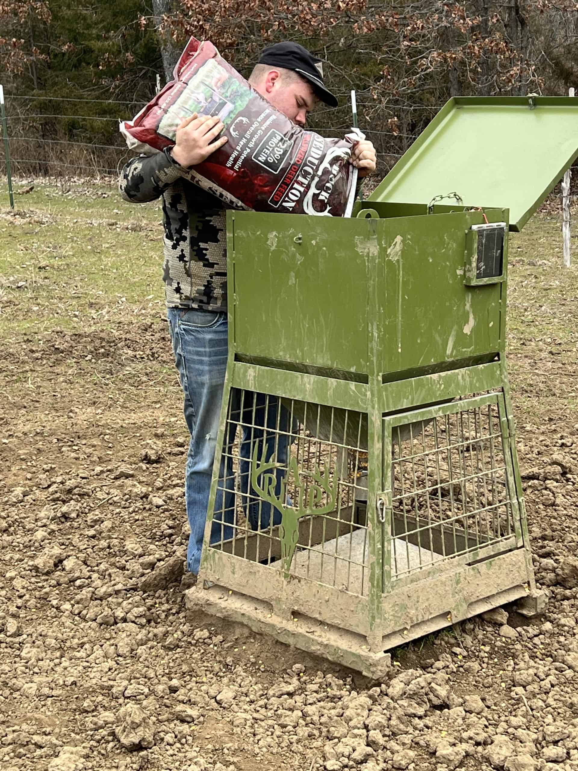 Kaden refills a deer feeder before setting off for a guided hunt.