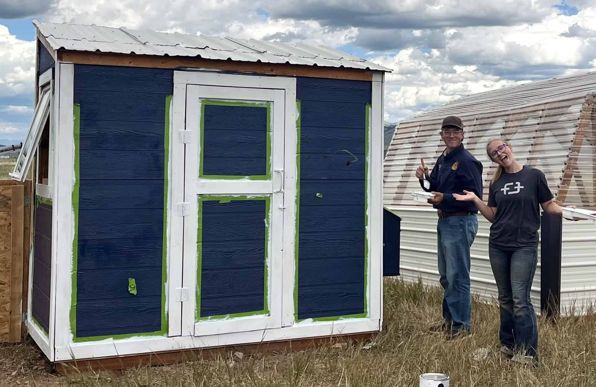 President Bridger Wolfley and Student Advisor Sam Bramwell paint chapter coop in preparation for new birds.