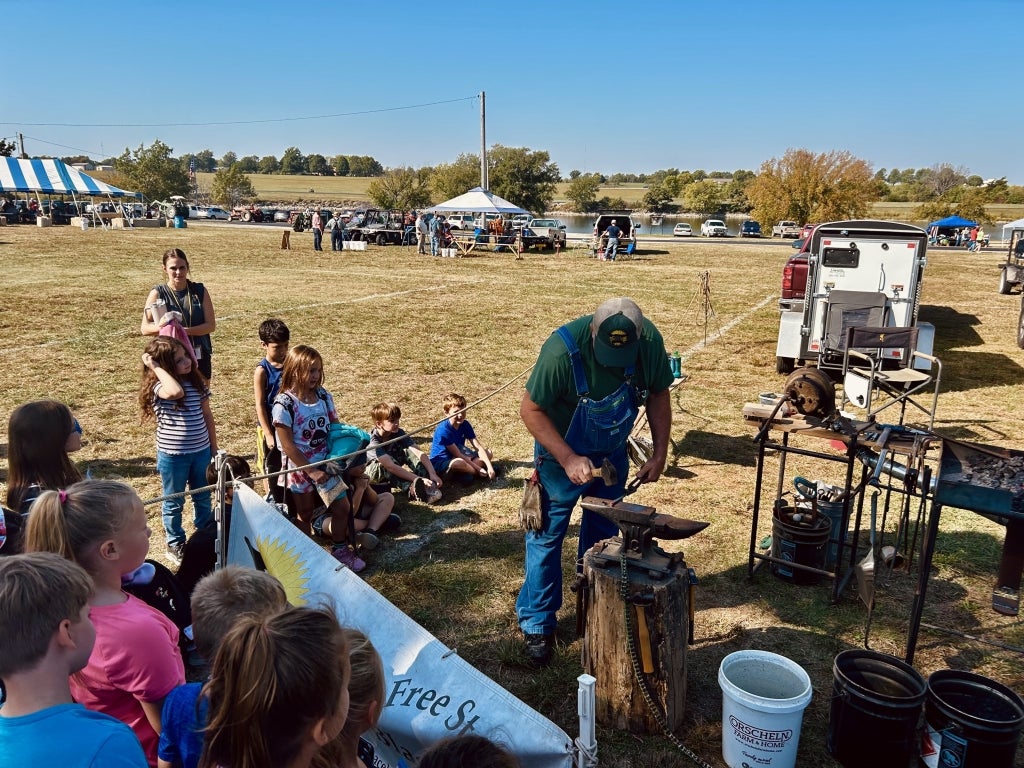 Participating students watch a blacksmith demonstration.