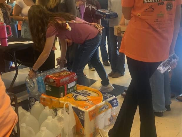 Students adding items to the supply drive pile as they register for RLC.