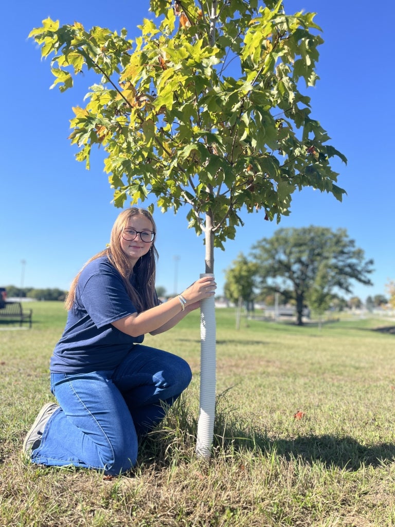 Claire Karus examines a tree in the Beaver Dam FFA forest.
