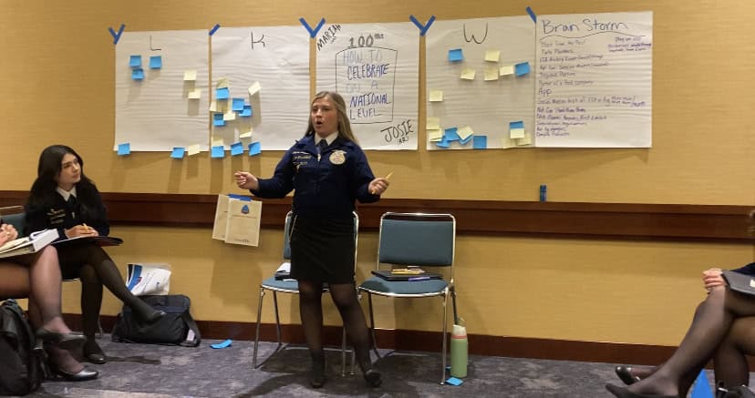 Leadership delegate leading a group discussion in the committee room.