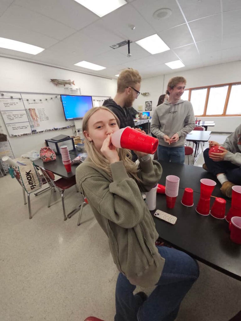 A Sheridan FFA member participates in a classroom activity using stacked plastic cups while other students work nearby.