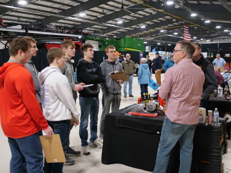 Members of the Patrick Henry FFA chapter talk with an exhibitor.